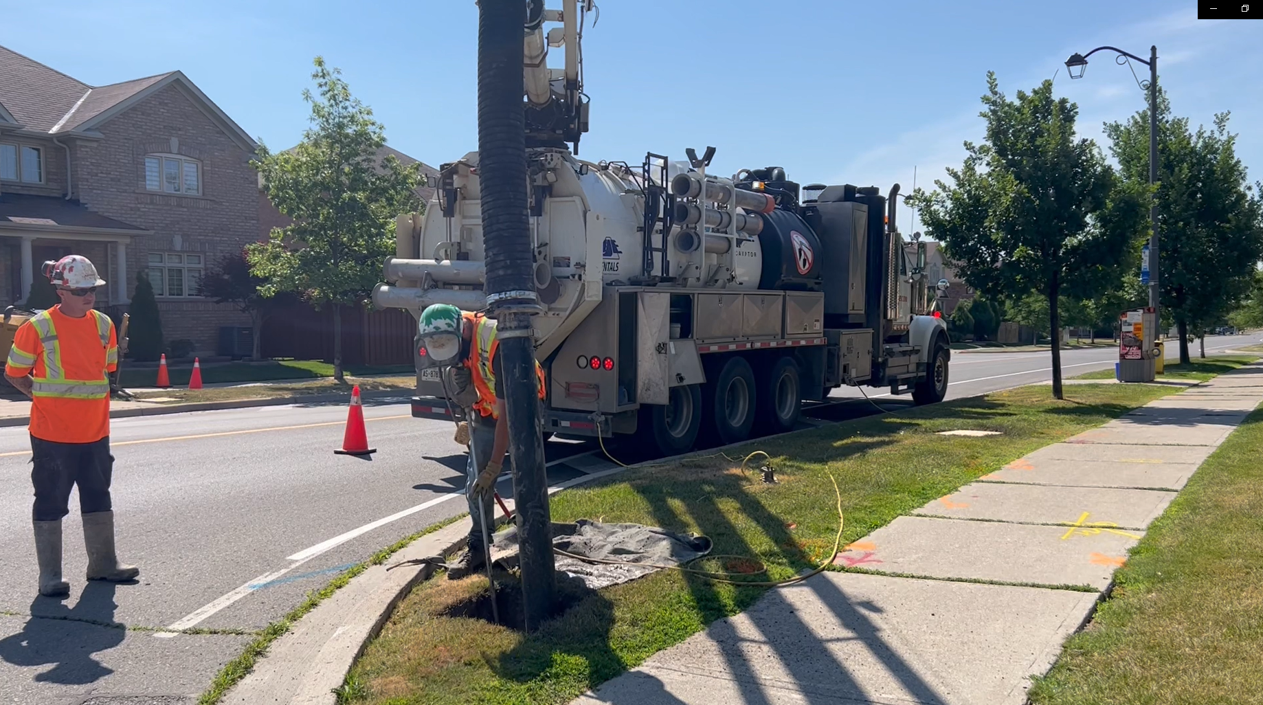 Two construction workers working on a residential street